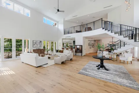 a living room with furniture white walls and a chandelier