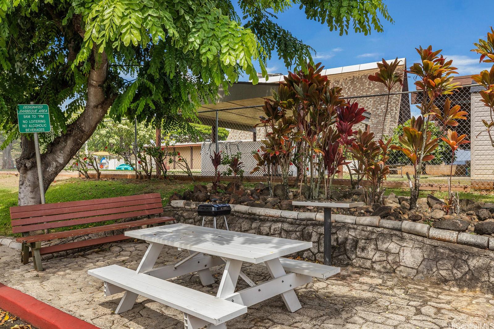 98-660 Moanalua Loop, Unit 276 Aiea, HI 96701 - Photo 22 of 25 a view of backyard with a table and chairs under an umbrella