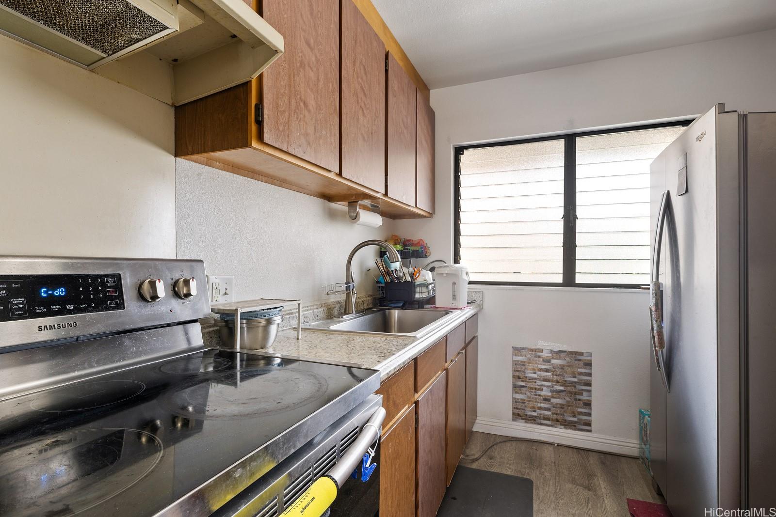 98-660 Moanalua Loop, Unit 276 Aiea, HI 96701 - Photo 5 of 25 a kitchen with a stove and a refrigerator