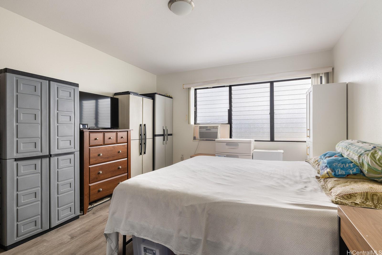 98-660 Moanalua Loop, Unit 276 Aiea, HI 96701 - Photo 9 of 25 a bedroom with a bed and a refrigerator