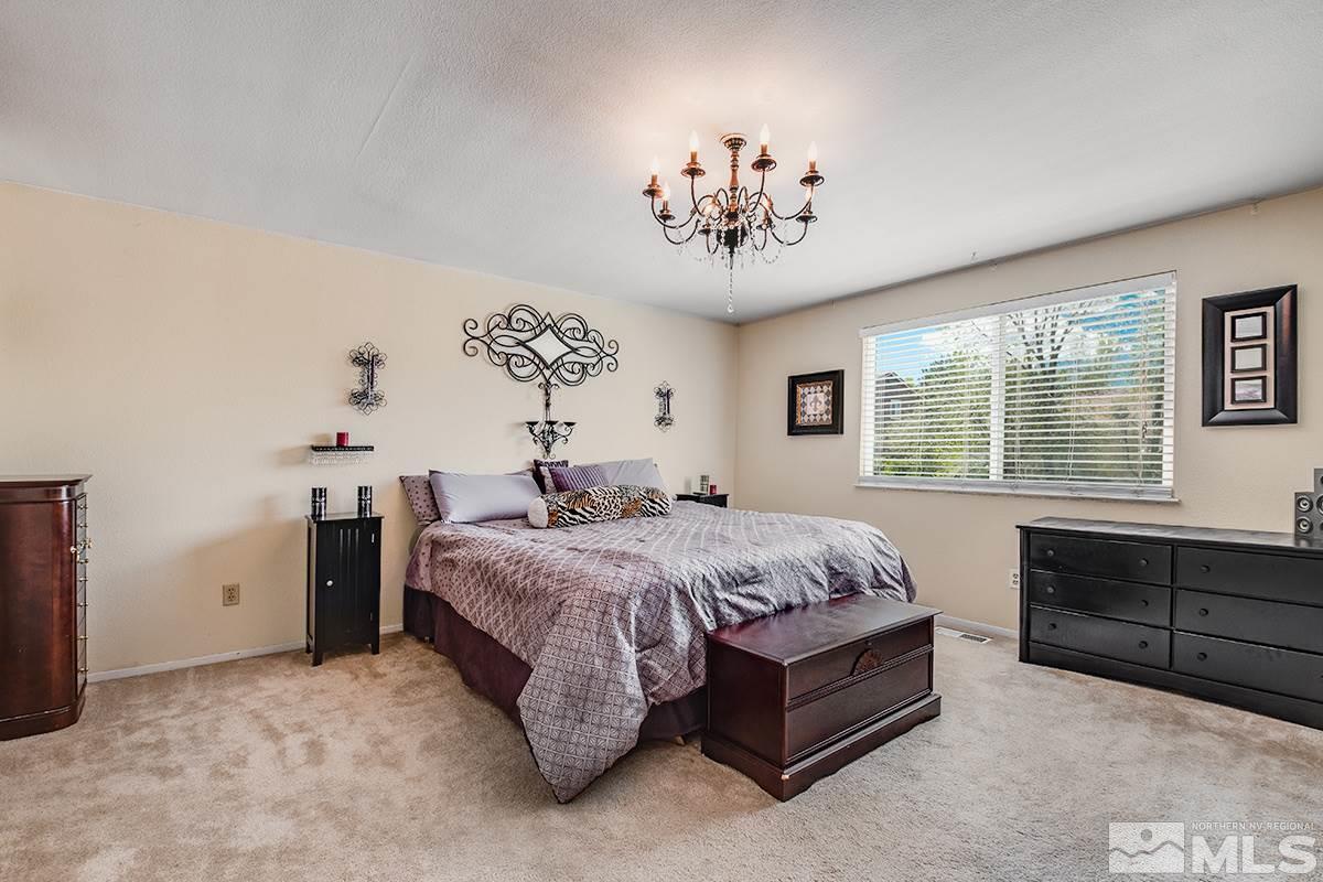 2642 Rayma Court Reno, NV 89503 - Photo 16 of 22 a spacious bedroom with a bed and a table