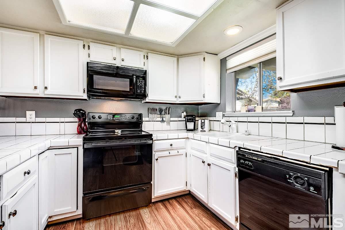2642 Rayma Court Reno, NV 89503 - Photo 6 of 22 a kitchen with stainless steel appliances white cabinets and a stove top oven