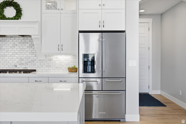 21 Pier Place Tooele, UT 84074 - Photo 26 of 112 Gourmet kitchen featuring a stainless steel French door refrigerator, white shaker cabinetry, white subway tile backsplash, and light-toned countertops