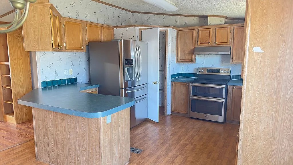 2607 George Street Round Rock, TX 78681 - Photo 2 of 14 a kitchen with stainless steel appliances granite countertop a refrigerator a stove and a sink