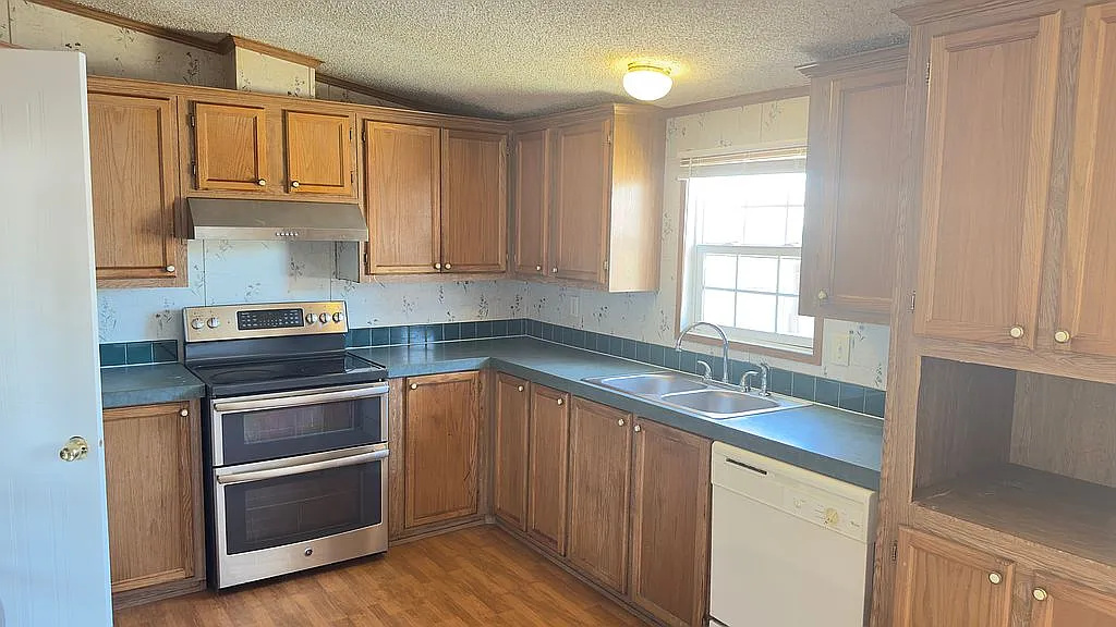 2607 George Street Round Rock, TX 78681 - Photo 9 of 14 a kitchen with granite countertop cabinets stainless steel appliances and a sink