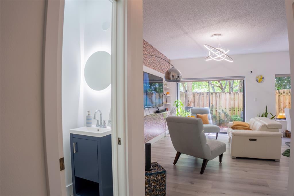 361 Southwest 95 Terrace, Unit 361 Pembroke Pines, FL 33025 - Photo 13 of 14 a living room with furniture a fireplace and a chandelier
