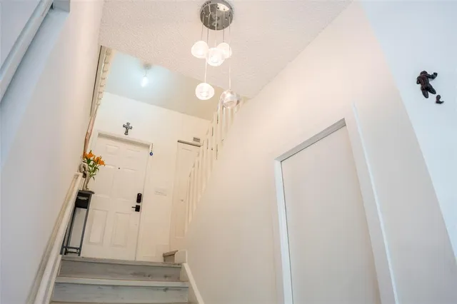 a view of a hallway with wooden floor and entryway