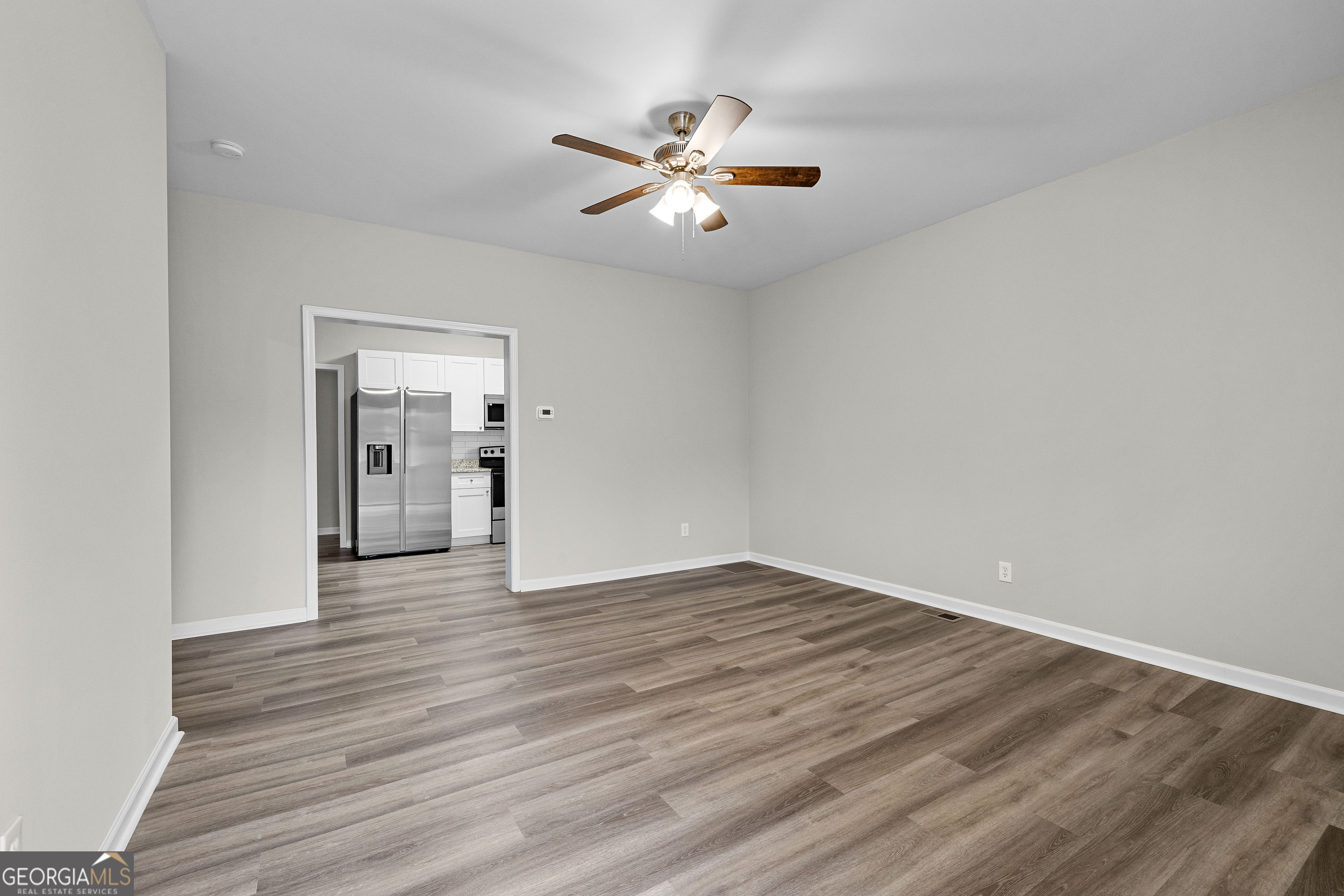 21 Shepard Street Grantville, GA 30220 - Photo 6 of 29 a view of an empty room with wooden floor and a ceiling fan