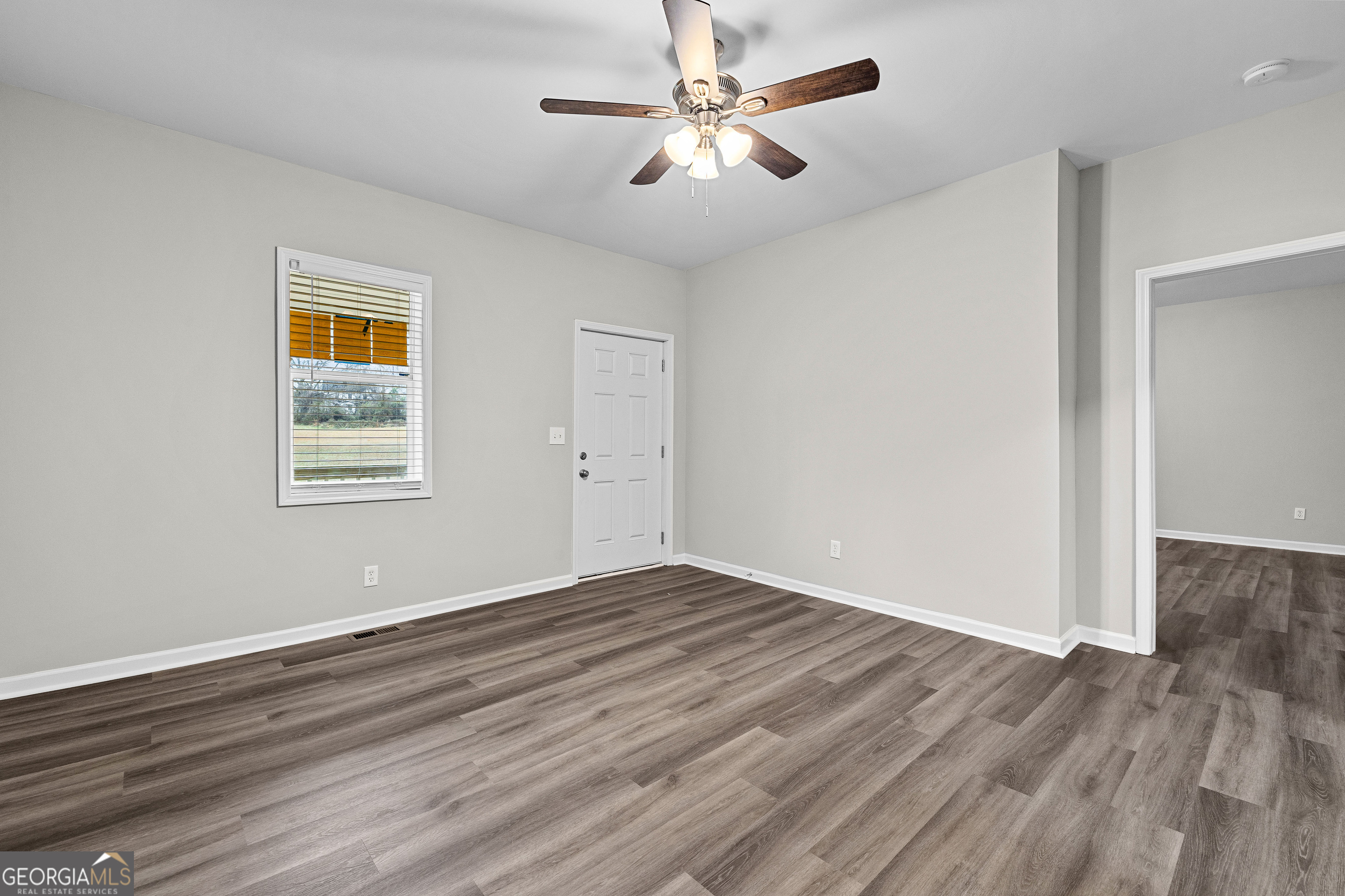 21 Shepard Street Grantville, GA 30220 - Photo 8 of 29 a view of an empty room with wooden floor and a ceiling fan