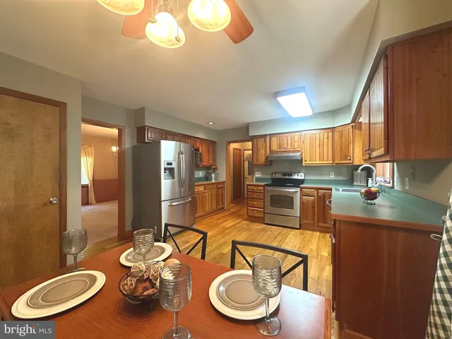 a kitchen with stainless steel appliances a dining table and chairs