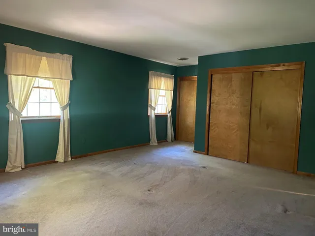 an empty room with windows and closet
