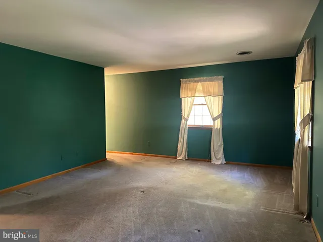 an empty room with window and a fireplace