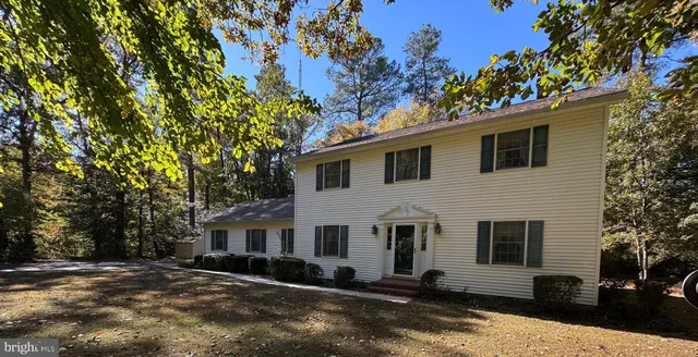 a view of a white house with a large tree