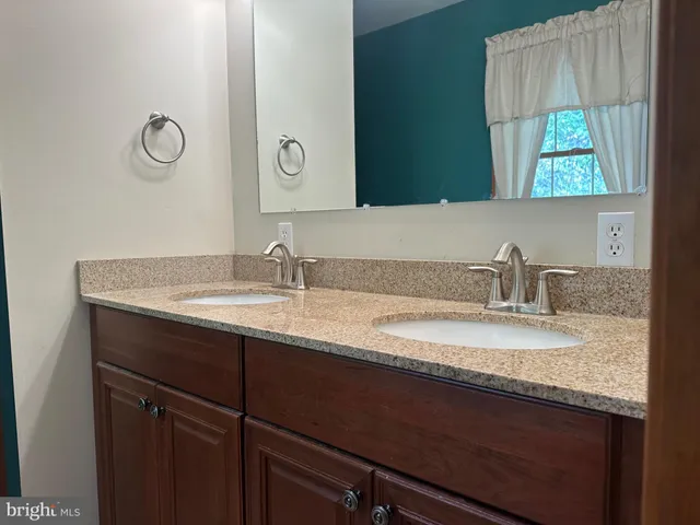 a bathroom with a granite countertop sink and a mirror