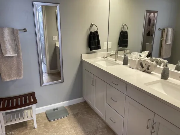 a bathroom with double vanity sink and two mirror