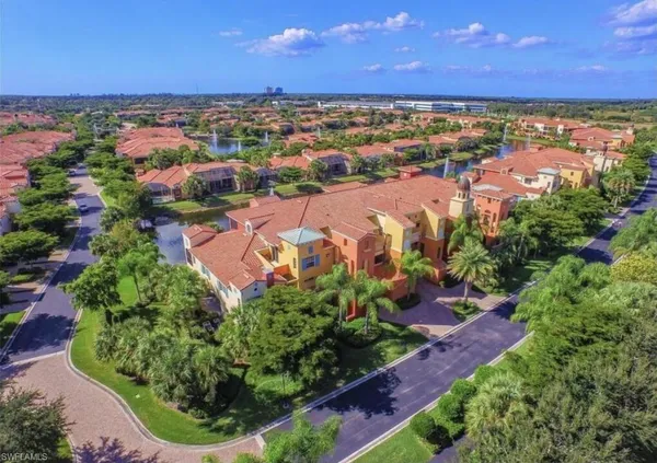 an aerial view of residential houses with outdoor space and trees