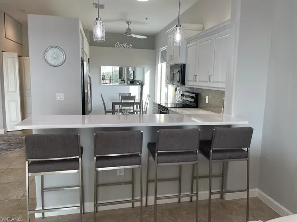 a kitchen with a table chairs refrigerator and microwave