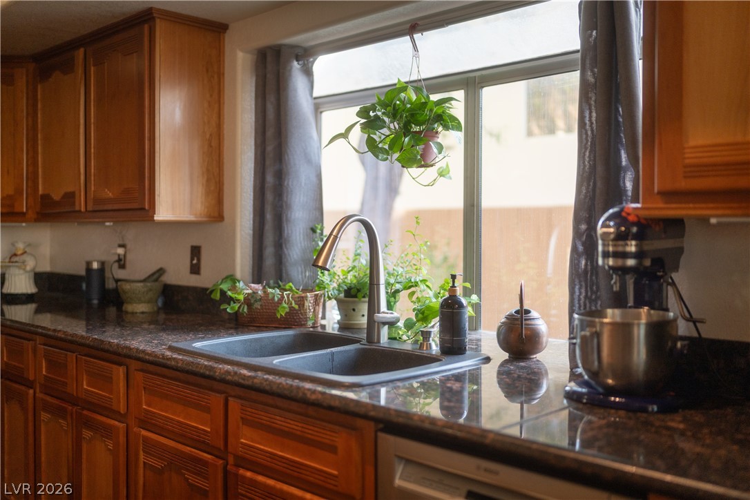 2108 Inverness Drive Henderson, NV 89074 - Photo 21 of 46 Kitchen with dishwasher, brown cabinetry, and dark stone countertops