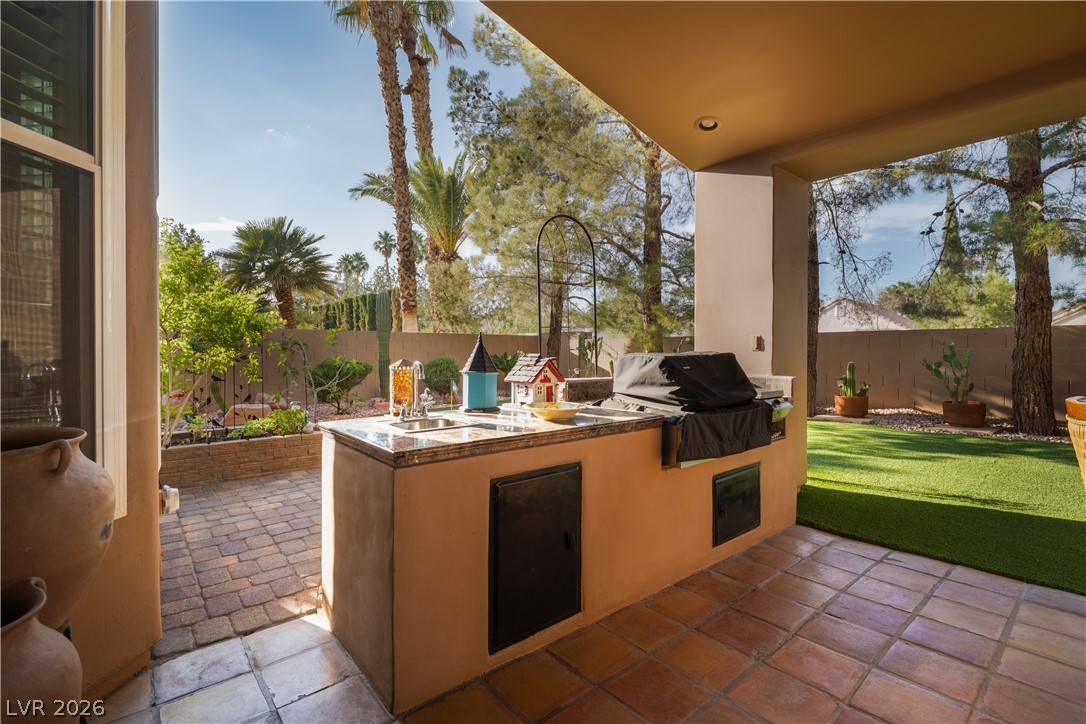 2108 Inverness Drive Henderson, NV 89074 - Photo 33 of 46 Fenced backyard featuring a patio and an outdoor kitchen