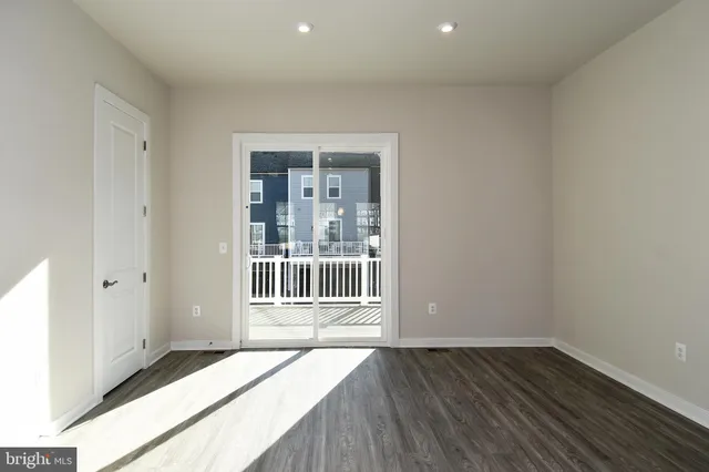 a kitchen with a stove a sink and wooden floor