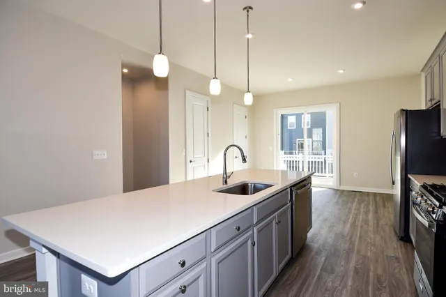 a view of a kitchen with wooden floor and electronic appliances