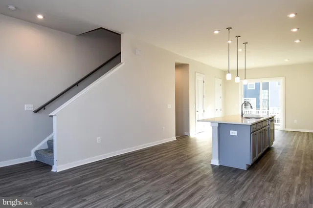 a kitchen with stainless steel appliances granite countertop a sink a refrigerator and wooden floor