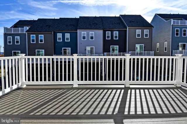 a view of an empty room with window and hardwood floor