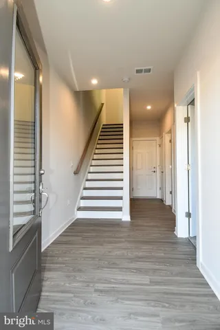 a view of a hallway with stairs and wooden floor