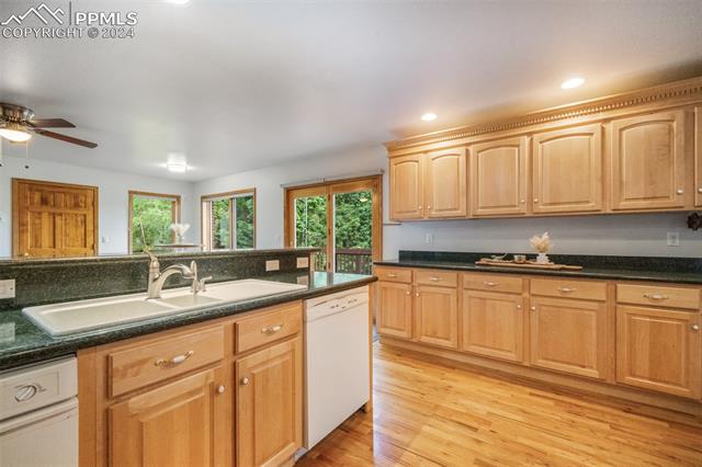 4735 Red Forest Road Monument, CO 80132 - Photo 13 of 50 Kitchen with gas stove, granite counters, maple cabinets, hardwood floors