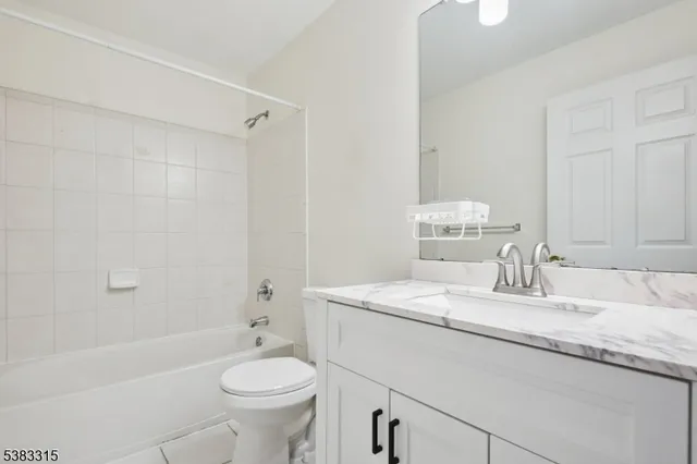 a bathroom with a granite countertop sink a toilet and a bathtub
