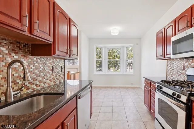 a kitchen with stainless steel appliances granite countertop a sink stove and cabinets