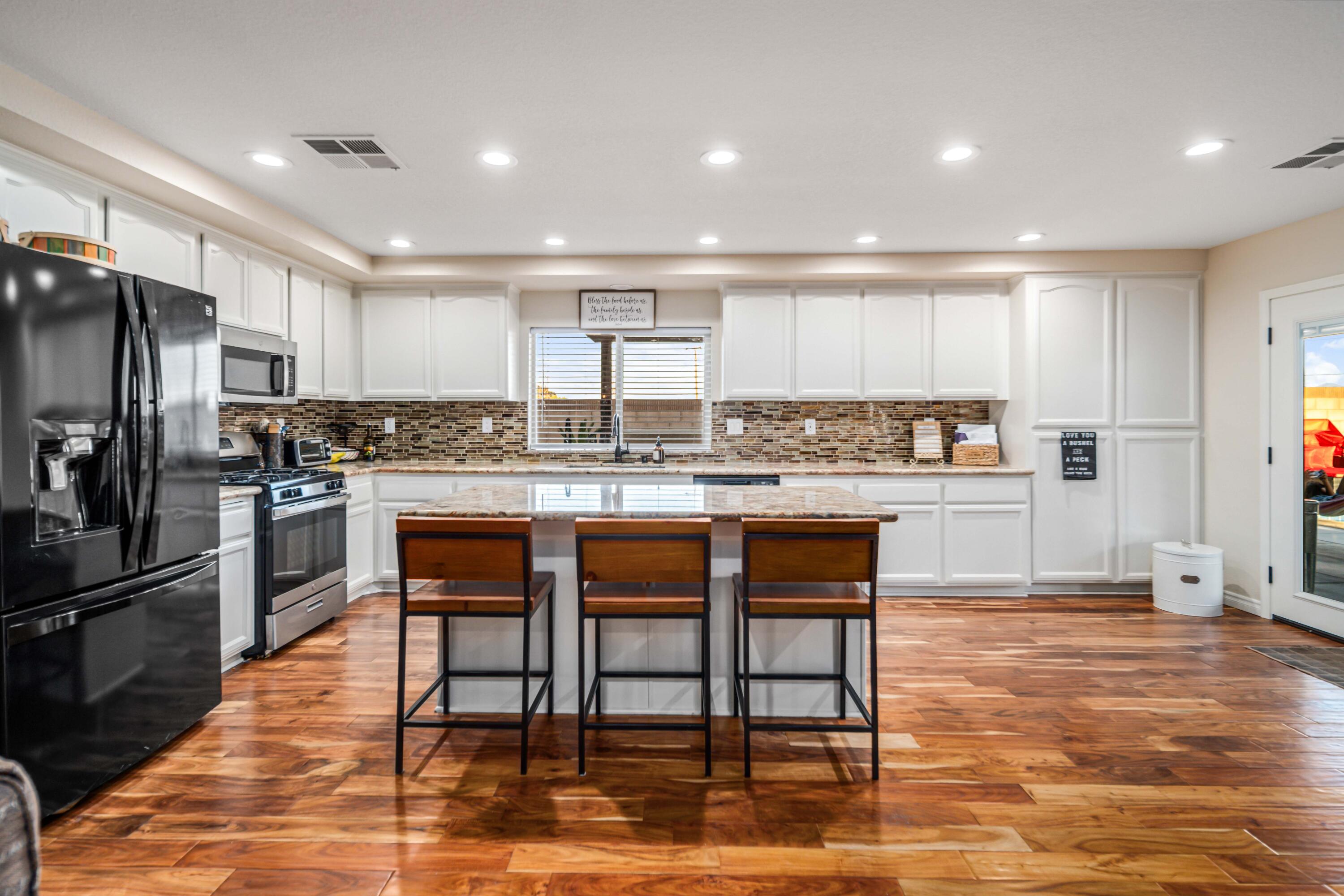6204 Shadow Hill Drive Lancaster, CA 93536 - Photo 19 of 82 a kitchen with stainless steel appliances kitchen island granite countertop a refrigerator and cabinets