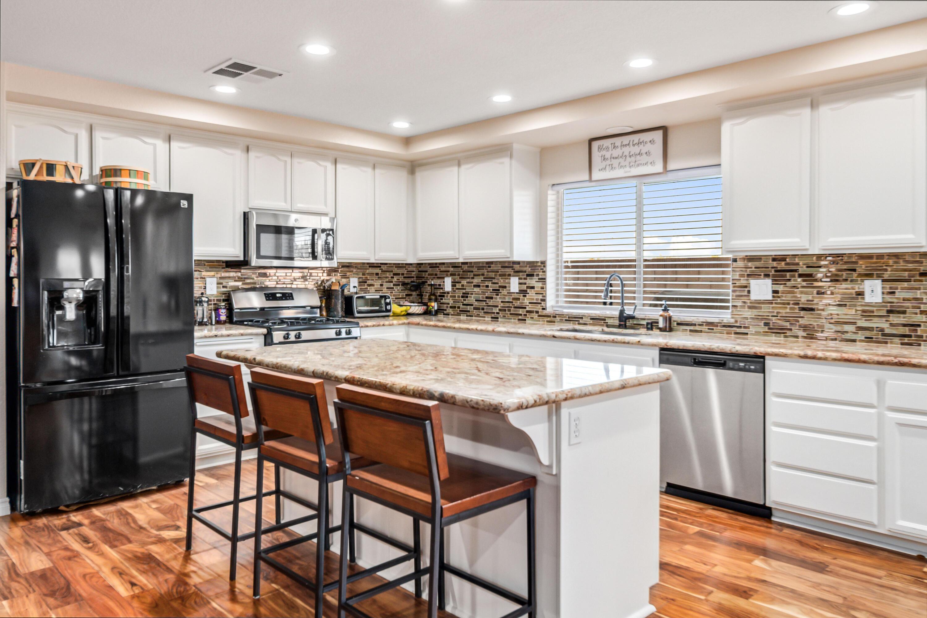 6204 Shadow Hill Drive Lancaster, CA 93536 - Photo 20 of 82 a kitchen with stainless steel appliances granite countertop a stove a sink a refrigerator white cabinets and wooden floor