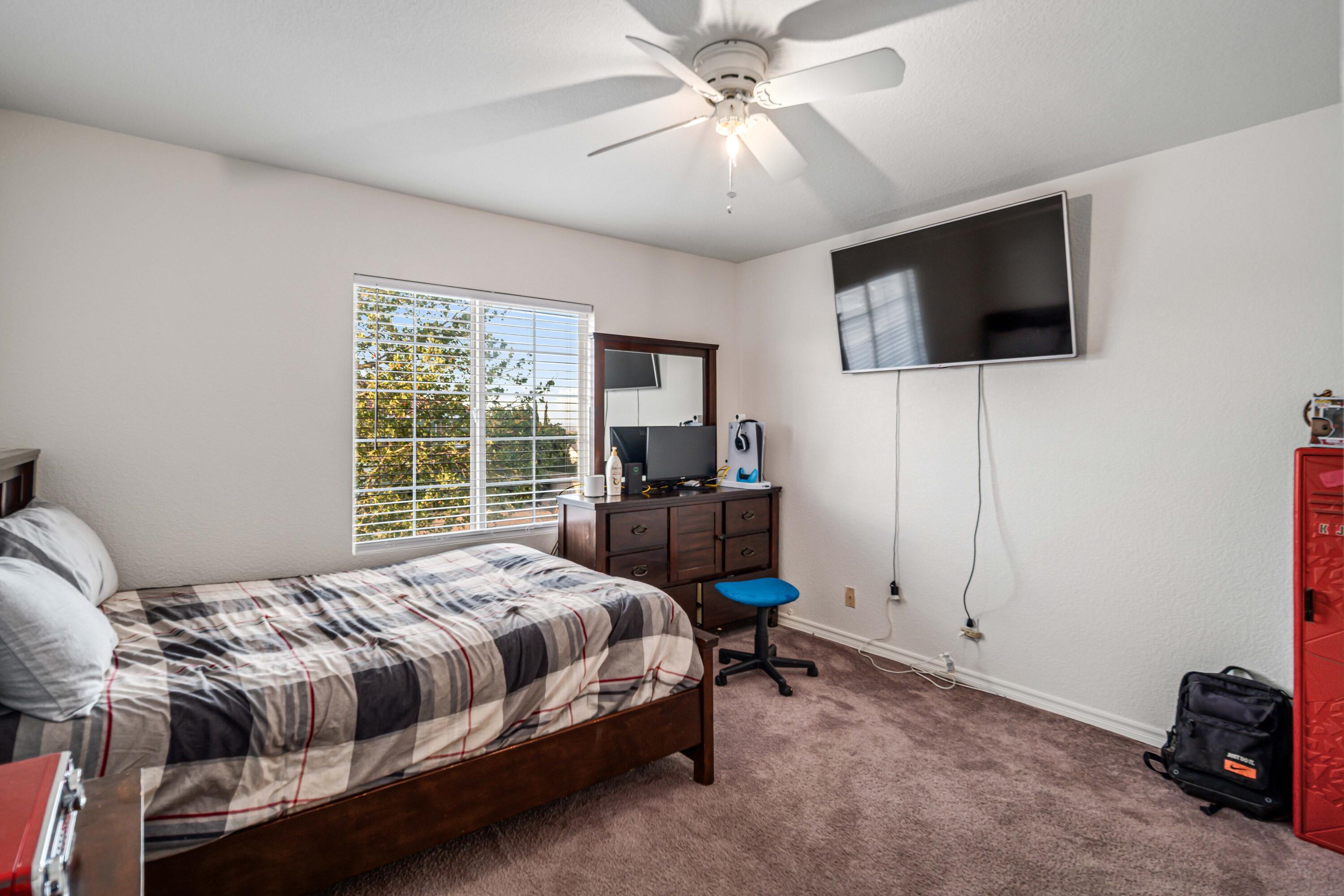 6204 Shadow Hill Drive Lancaster, CA 93536 - Photo 41 of 82 a bedroom with a bed a tv and wooden floor