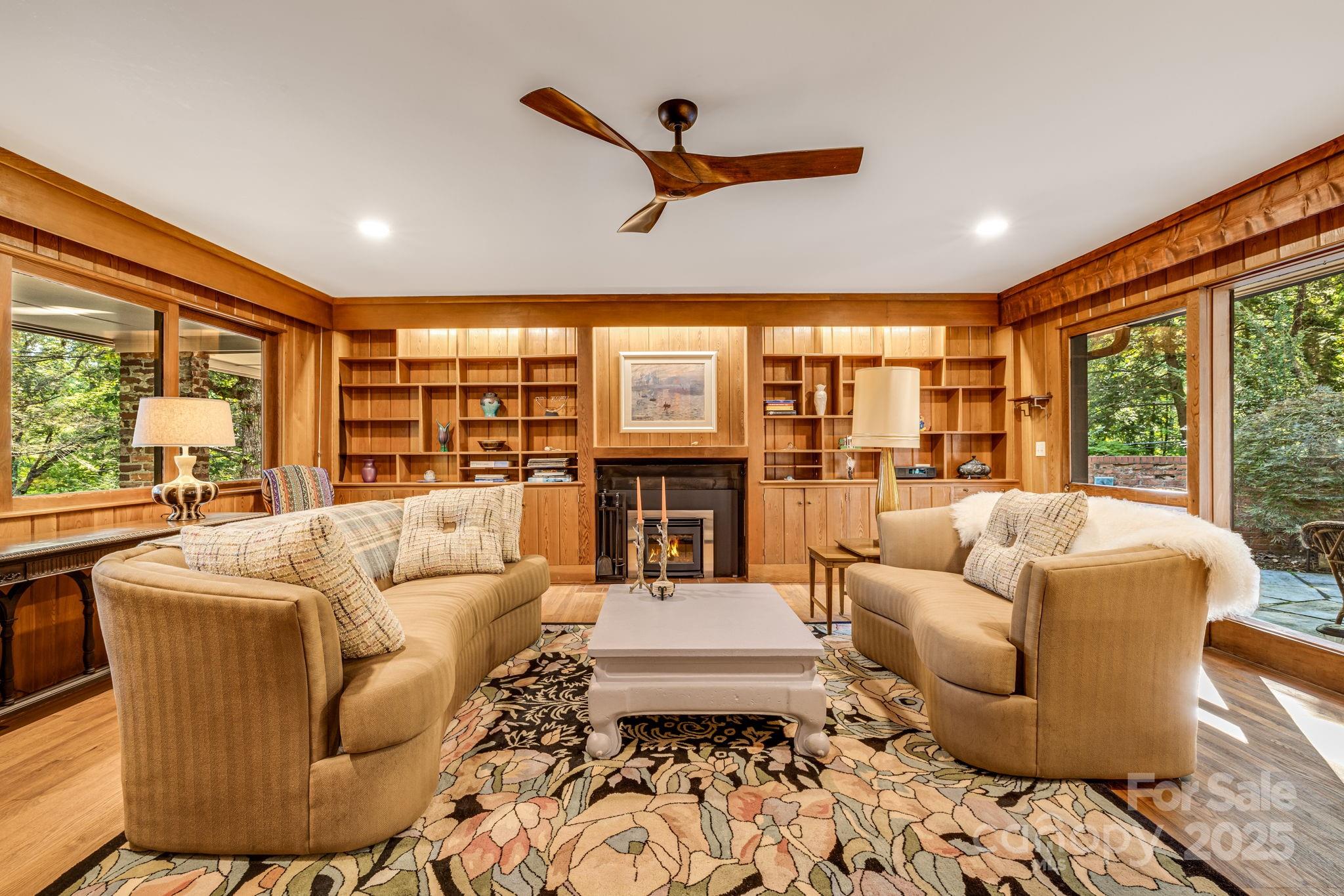 750 Braewick Road Tryon, NC 28782 - Photo 11 of 43 a living room with furniture large windows plants and wooden floor