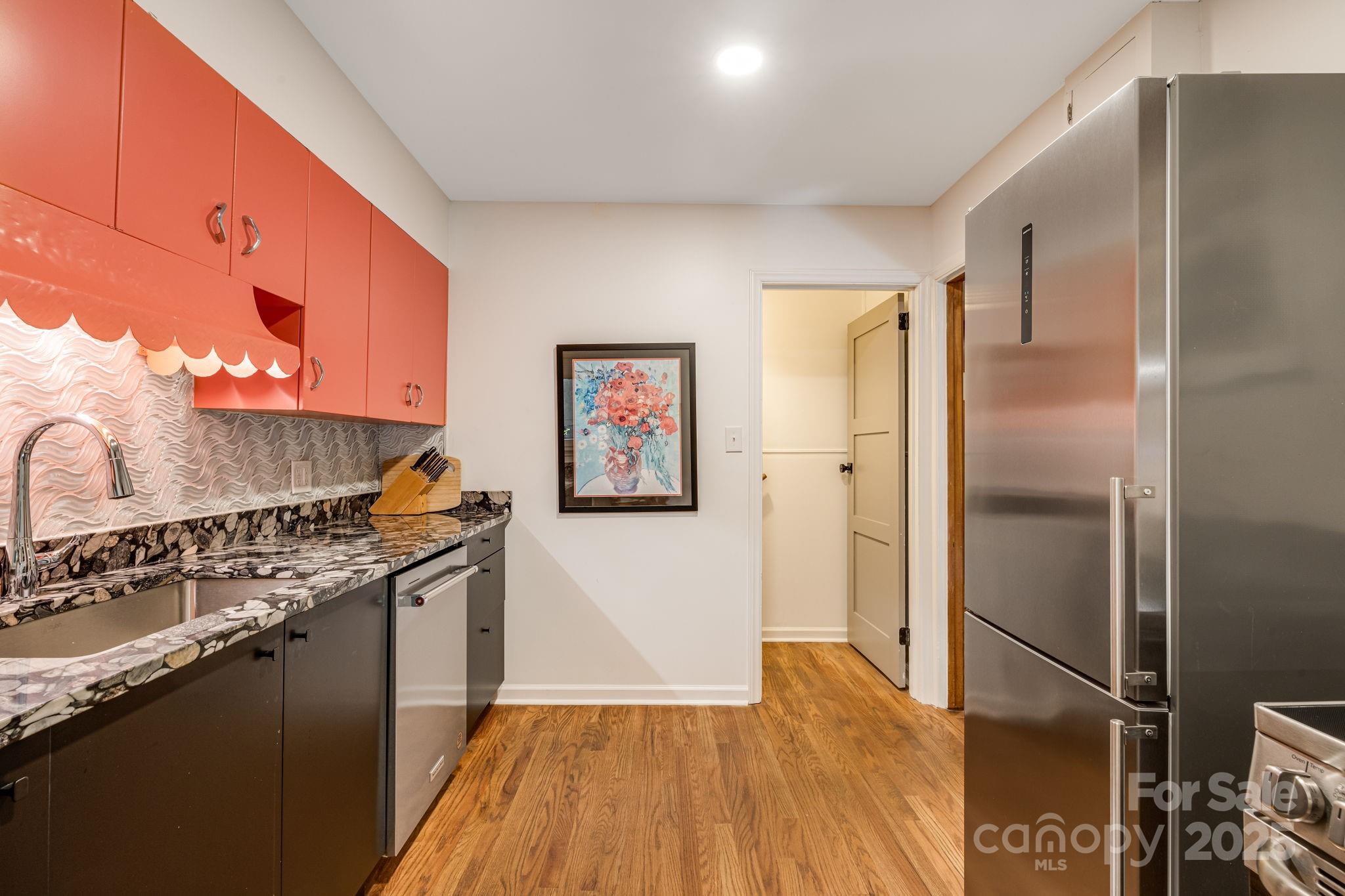 750 Braewick Road Tryon, NC 28782 - Photo 19 of 43 a kitchen with stainless steel appliances granite countertop a refrigerator a stove and a wooden floor