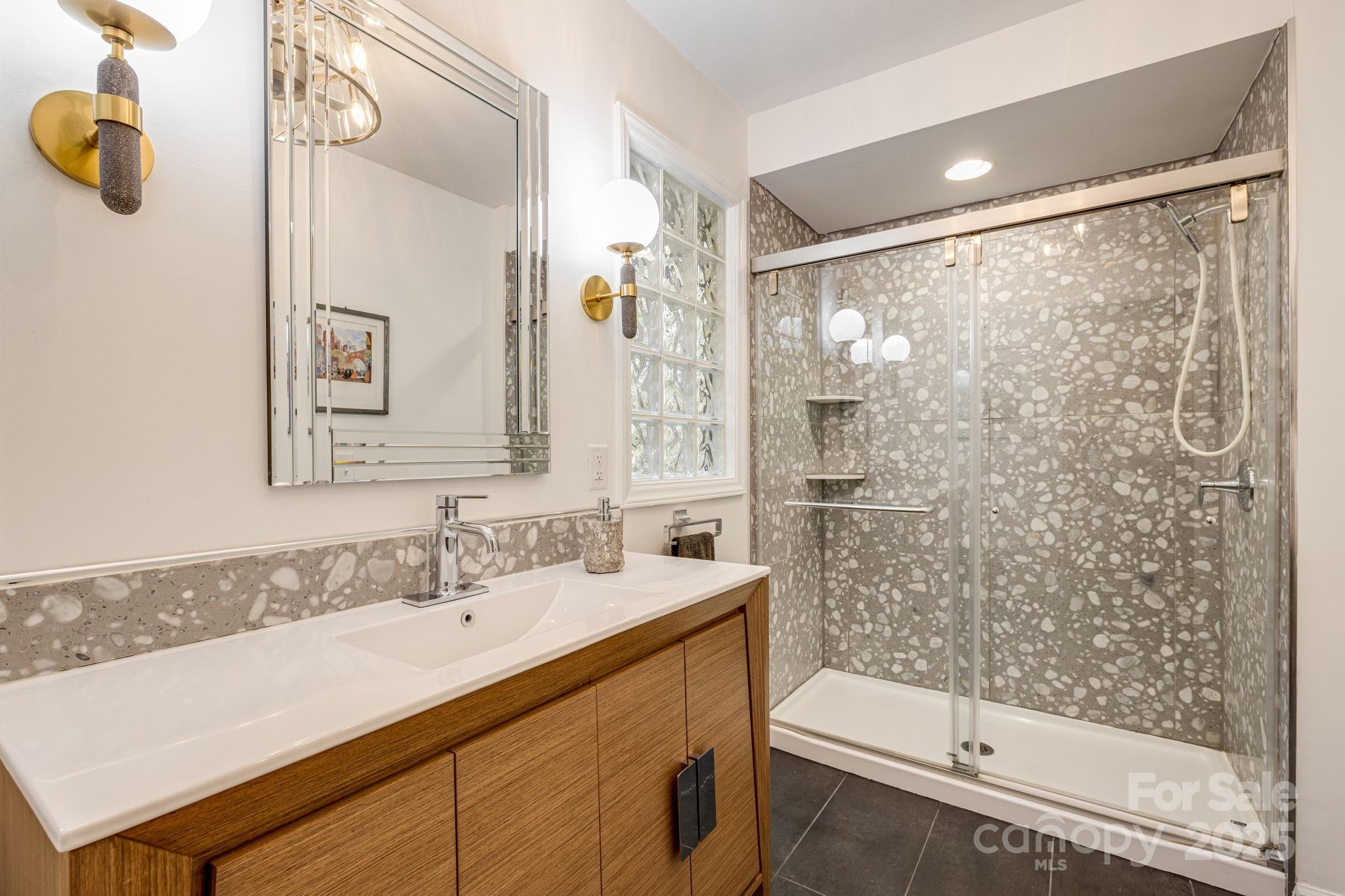 750 Braewick Road Tryon, NC 28782 - Photo 24 of 43 a bathroom with a sink mirror and a shower