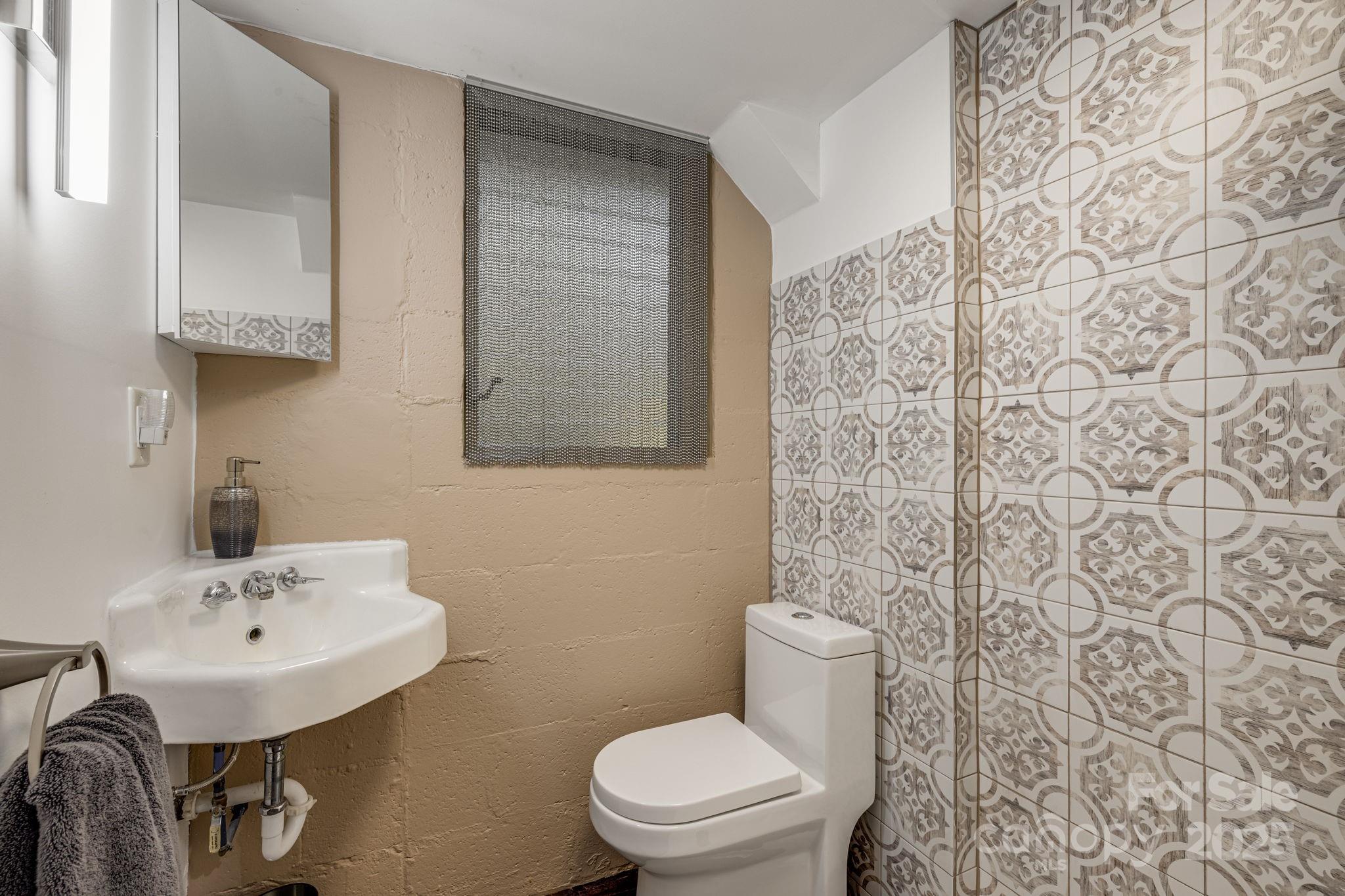750 Braewick Road Tryon, NC 28782 - Photo 30 of 43 a bathroom with a sink a toilet and shower curtain