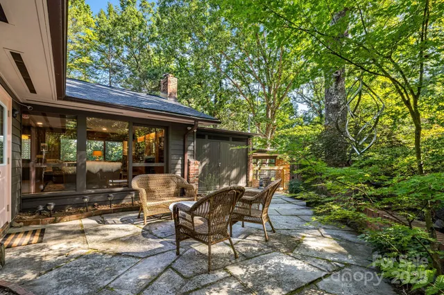 a backyard of a house with barbeque oven table and chairs