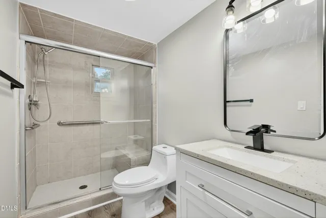 a bathroom with a sink a toilet and shower