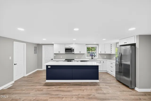 a large kitchen with kitchen island a sink stainless steel appliances and cabinets