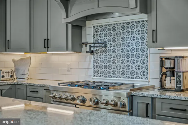 a dining room with stainless steel appliances kitchen island granite countertop a dining table chairs and granite counter tops