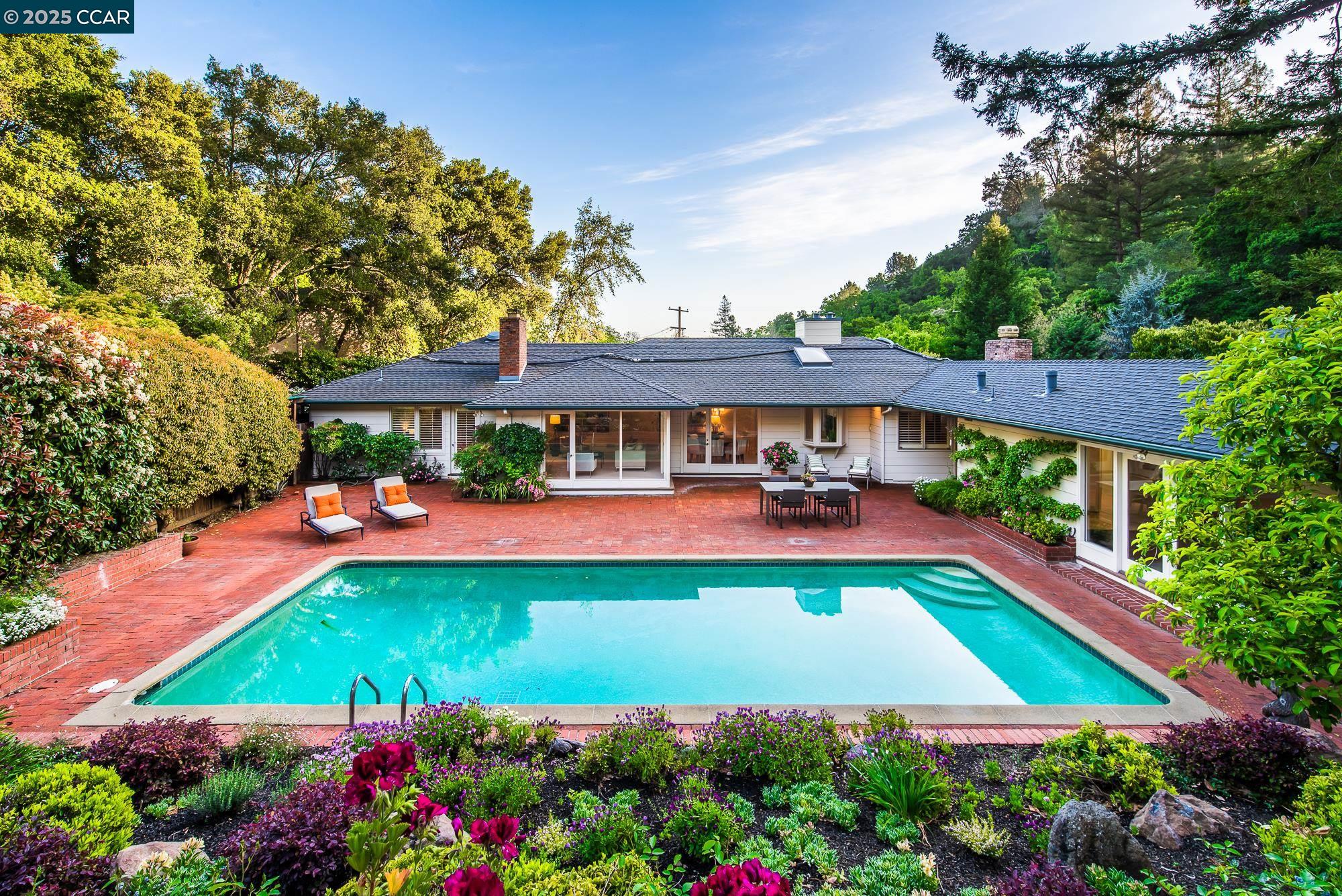 a front view of a house with swimming pool patio and outdoor seating
