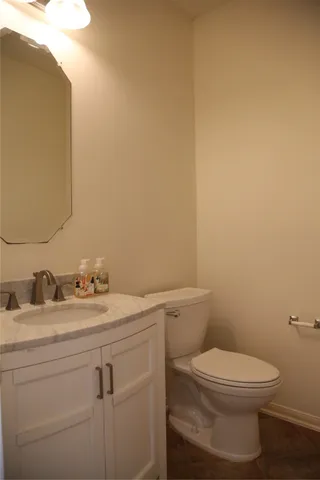 an empty room with chandelier fan and windows