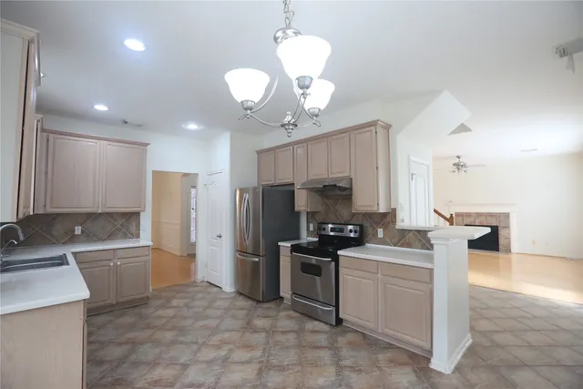 a large kitchen with kitchen island a large counter space and stainless steel appliances
