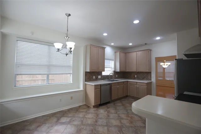a kitchen with granite countertop a refrigerator and a sink