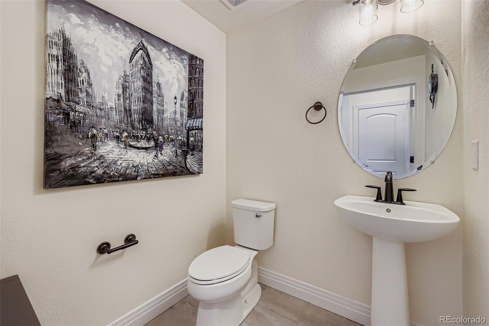 1835 Rose Quartz Heights Colorado Springs, CO 80908 - Photo 13 of 31 a bathroom with a toilet sink and mirror