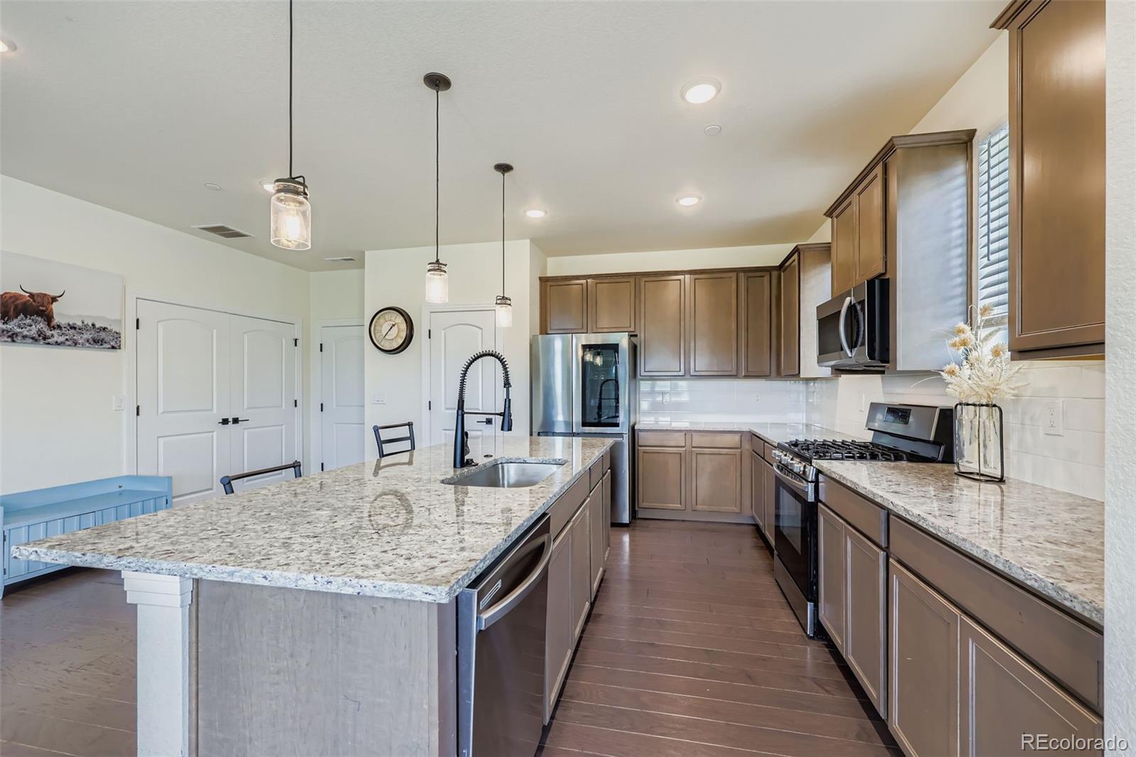 1835 Rose Quartz Heights Colorado Springs, CO 80908 - Photo 9 of 31 a large kitchen with granite countertop a stove oven and a sink