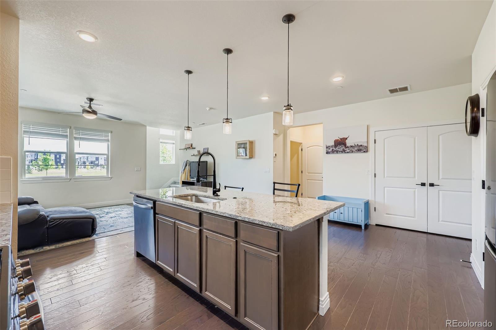 1835 Rose Quartz Heights Colorado Springs, CO 80908 - Photo 10 of 31 a kitchen with kitchen island a sink stove and wooden floor