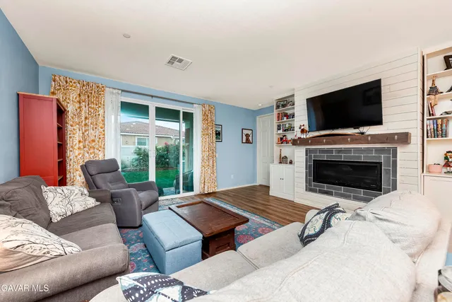 a living room with furniture a flat screen tv and a fireplace